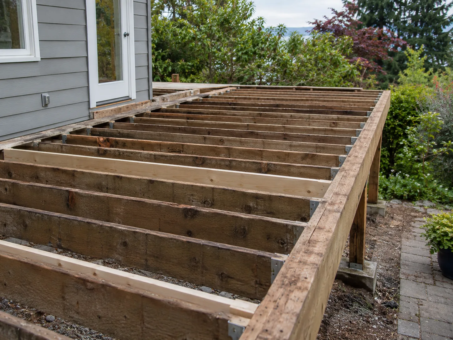 Exposed deck joists during a backyard rebuild