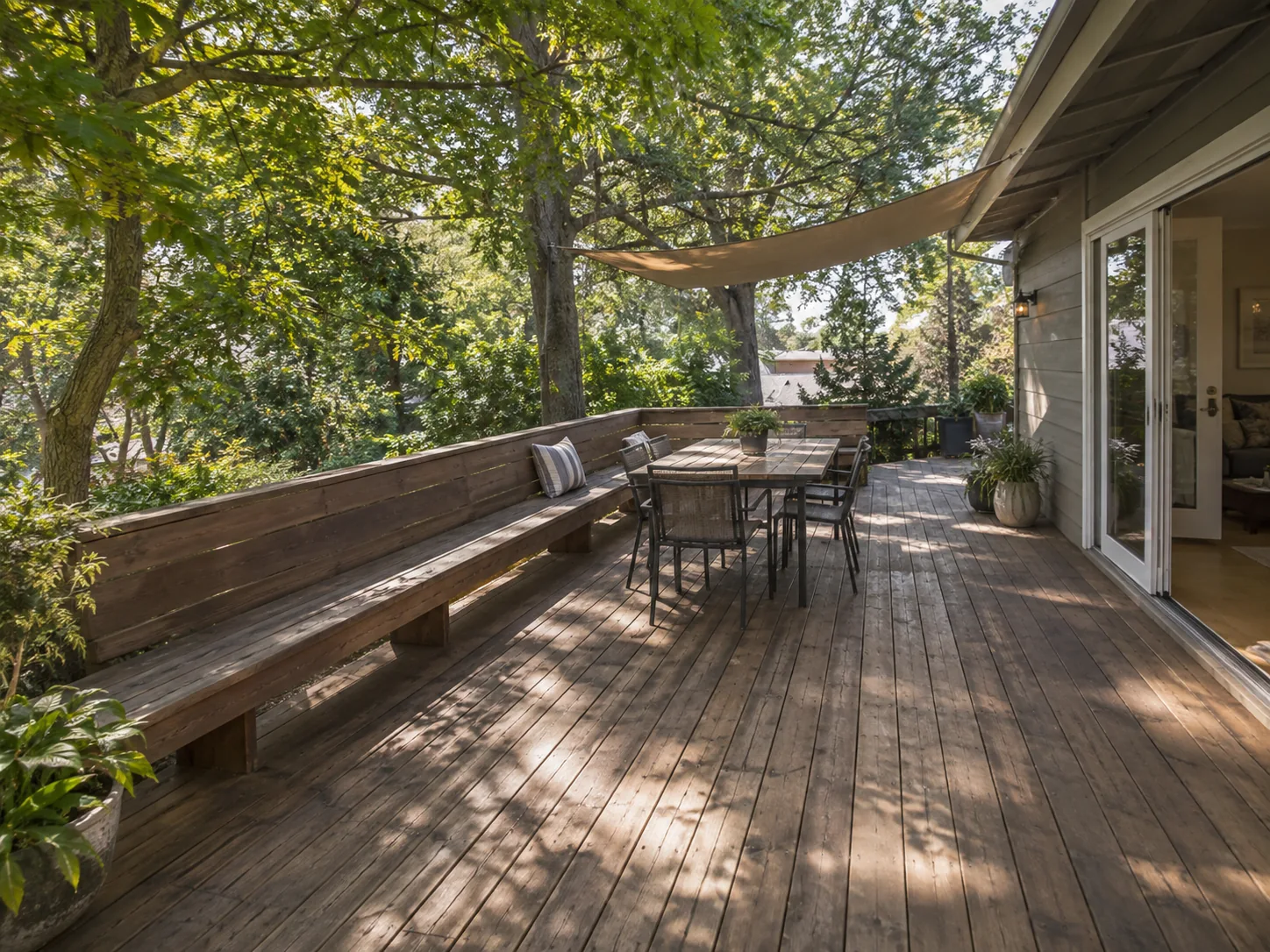 Wood deck with a long bench in a shaded backyard